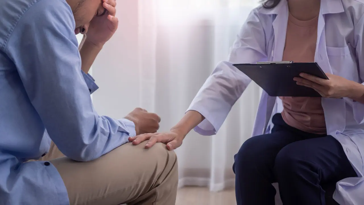 Medical consultation scene showing a healthcare professional examining a patient lying on an examination table in a modern medical office